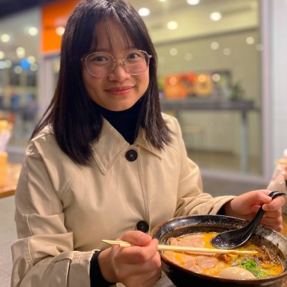 Photo of Ngoc smiling with a bowl of ramen