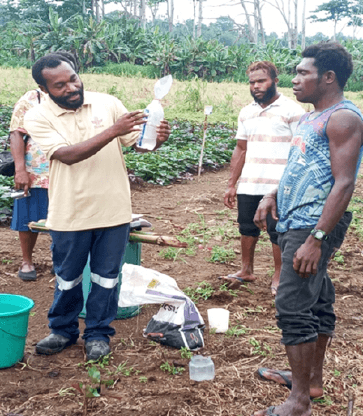 NARI's Alex Galus demonstrating how to use a rain gauge with farmers in East New Britain province (Source: NARI, 2020)