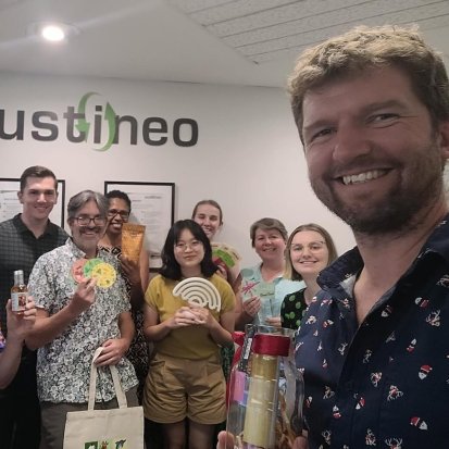 Selfie of the Sustineo team smiling under a 'sustineo' sign