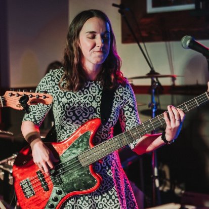 Kate playing bass guitar at an event